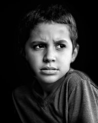 Close-up of cute boy against black background