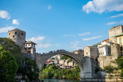 Arch bridge over river against sky