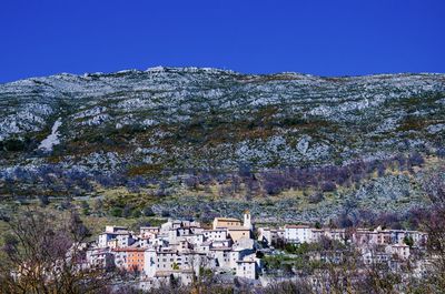 Buildings in town against clear blue sky