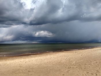 Scenic view of sea against storm clouds