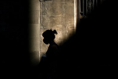 Side view of silhouette man and woman walking on window