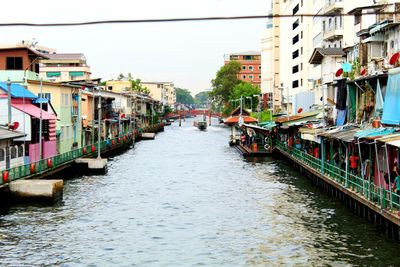 Canal amidst buildings in city against clear sky