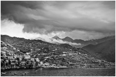 Scenic view of townscape by mountains against sky