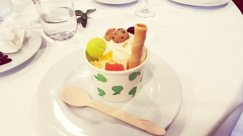 Close-up of ice cream in cup on plate over table