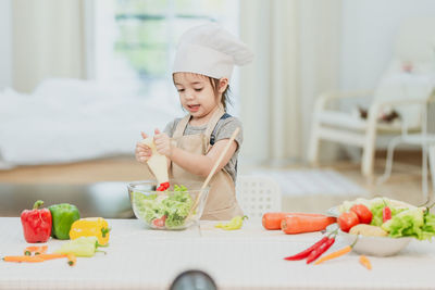 Midsection of woman eating food in kitchen
