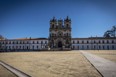 Facade of historic building against clear blue sky, alcobaca monastery
