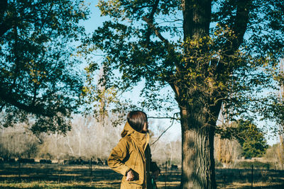 Full length of boy on tree trunk