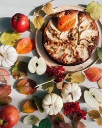 Overhead view of apple pie decorated autumn leaves
