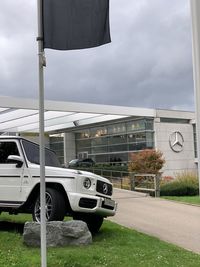 Cars on road by buildings against sky