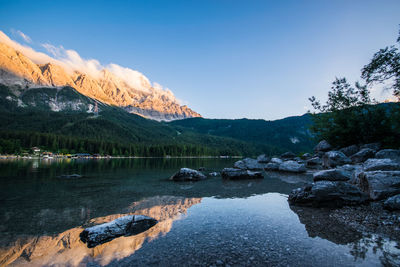 Scenic view of lake by snowcapped mountains against sky