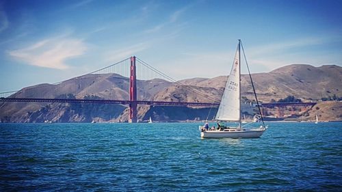 View of suspension bridge over sea against blue sky