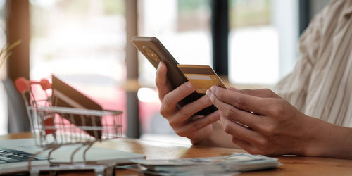 Midsection of woman using mobile phone