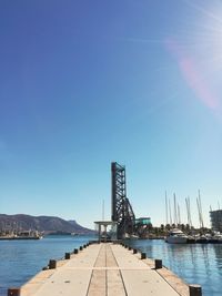 Sailboats in sea against blue sky