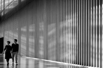 Full length of man and woman standing on tiled floor