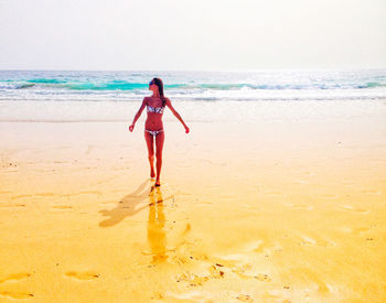 Full length of woman standing on beach