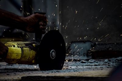 Cropped hand of worker using circular saw at workshop