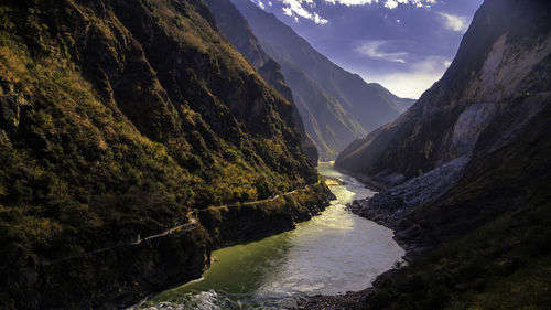 Scenic view of river amidst mountains against sky