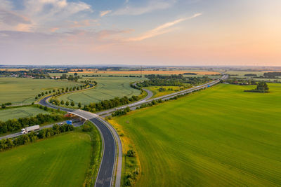 Scenic view of agricultural field against sky during sunset