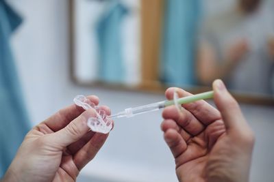 Young man preparing silicon tray for teeth whitening and bleaching gel syringe.