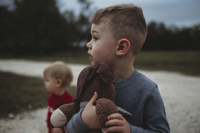 Boys looking away while standing on field