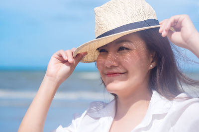 Smiling woman wearing hat standing outdoors