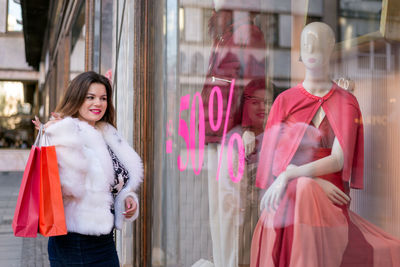 Happy woman standing by window in store