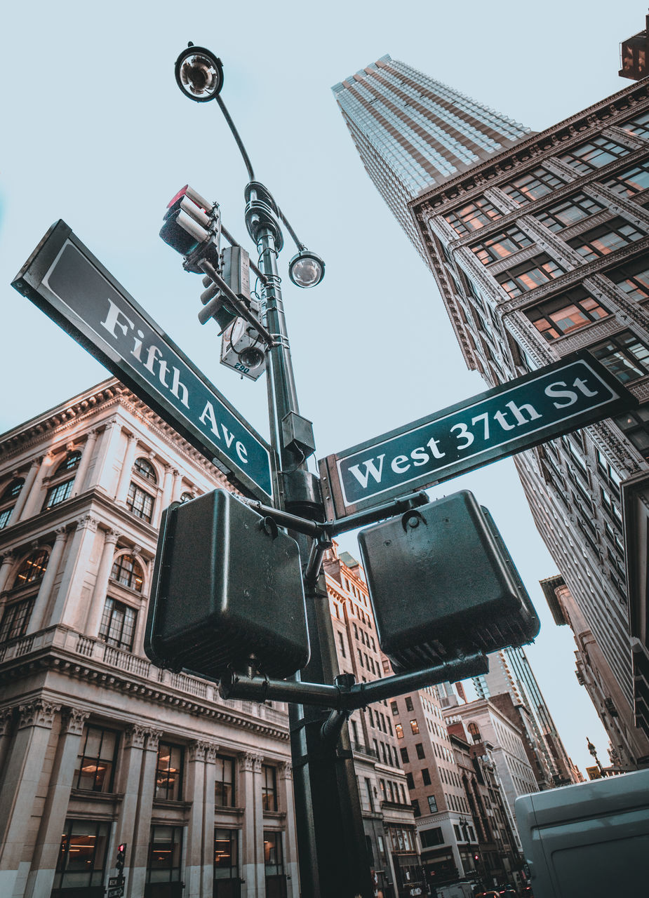 LOW ANGLE VIEW OF ROAD SIGN AGAINST BUILDINGS