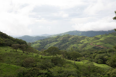 Scenic view of mountains against cloudy sky