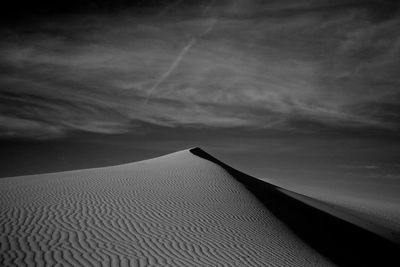 Scenic view of sand dunes against sky