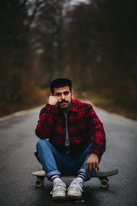 Young man wearing hat sitting outdoors