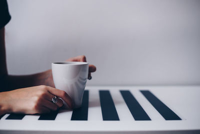 Hand holding coffee cup on table