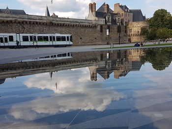 Reflection of building on lake against sky