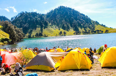 Group of people on shore against trees