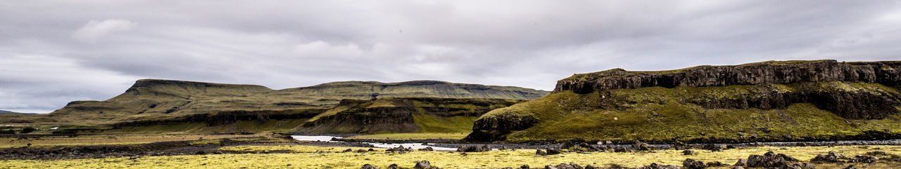 Scenic view of mountains against cloudy sky