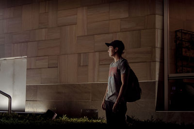 Side view of man walking against wall