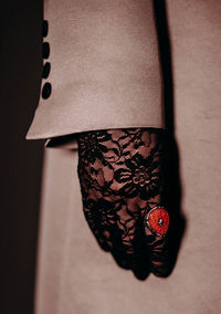 Signet ring with red stone, lace and black gloves and beige women's fashionable coat 