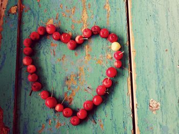 Close-up of heart shape made from cherries on wooden table