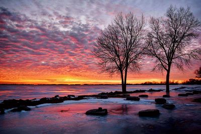 Scenic view of sea against dramatic sky during sunset