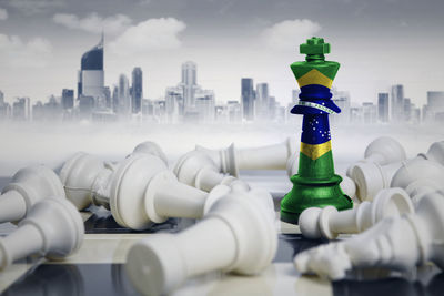 Close-up of chess pieces against buildings in city