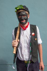 Portrait of young man standing against wall