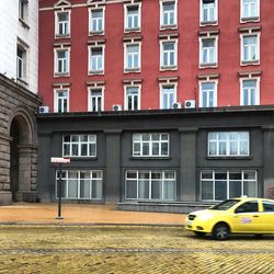 Red yellow car on city street