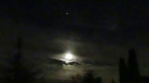 Low angle view of moon against cloudy sky