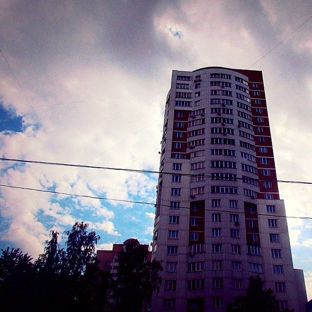 building exterior, low angle view, architecture, built structure, sky, cloud - sky, city, cloudy, building, cloud, residential building, residential structure, power line, tree, outdoors, no people, day, street light, tall - high, window