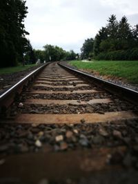 Close-up of railroad track amidst trees against sky