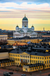 Buildings in city against sky during sunset