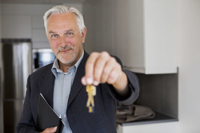 Portrait of confident real estate agent holding new house keys