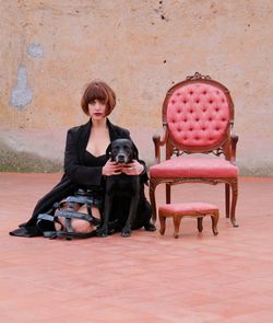 Portrait of woman with dog sitting on seat