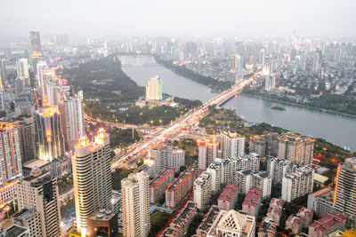 High angle view of illuminated city buildings against sky