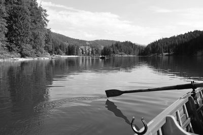 Rowing wooden boat on braies lake, trentino alto adige, italy. black and white.