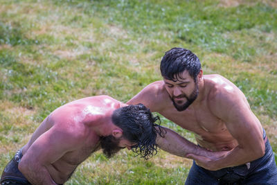 Full length of shirtless man lying on field